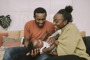 Happy parents tickling baby boy at home - MFF08458