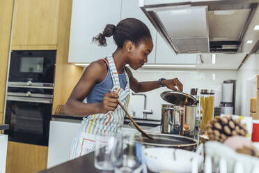 Vorpubertäres Mädchen kocht Essen in der Küche - MFF08491