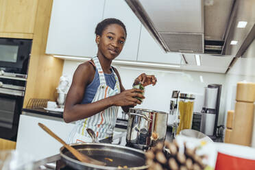 Vorpubertäres Mädchen bei der Zubereitung von Essen in der Küche zu Hause - MFF08492