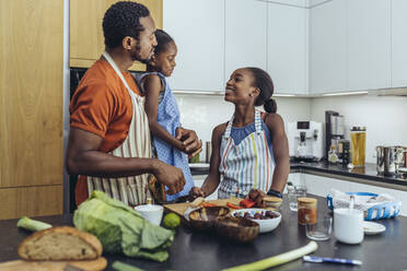 Father talking with daughters in kitchen - MFF08493