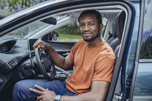 Lächelnder Mann im Auto sitzend - MFF08529