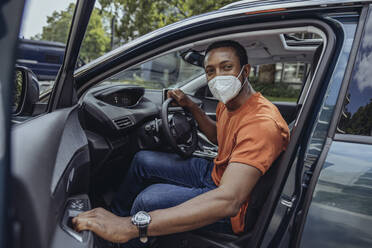 Man with protective face mask in car - MFF08531