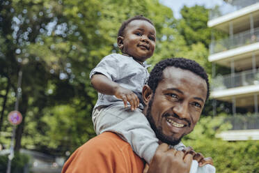 Lächelnder Vater trägt seinen Sohn auf den Schultern - MFF08542