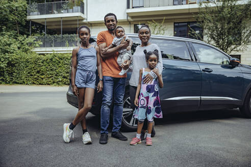 Familie vor einem Auto auf der Straße stehend - MFF08543