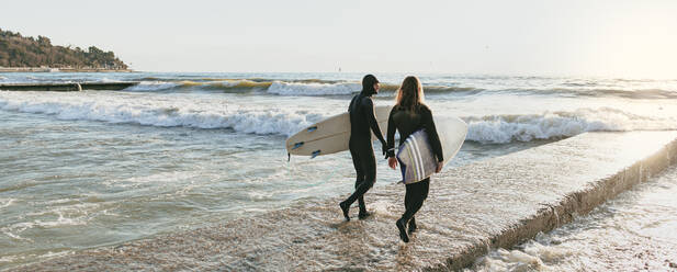 Surfer auf Betonsteg mit Surfbrett - OMIF00654