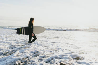 Surfer mit Surfbrett im Wasser am Strand - OMIF00659