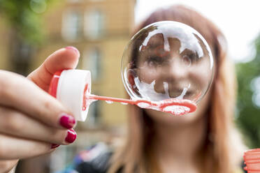 Young woman showing soap bubble - WPEF05820