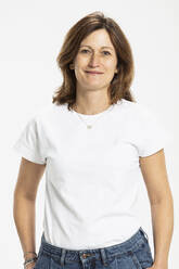 Smiling woman standing with hands in pocket against white background - SDAHF01111