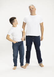 Junge mit Vater stehend vor weißem Hintergrund im Studio - SDAHF01126