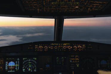Idyllic sunset seen through illuminated cockpit - PNAF03248