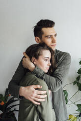 Junger Mann umarmt Freundin zu Hause - VPIF05354