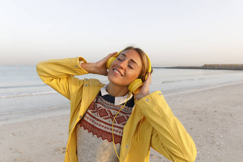 Glückliche Frau genießt Musik am Strand - TYF00085