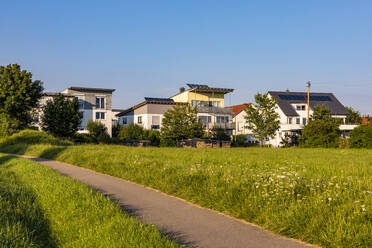 Deutschland, Baden-Württemberg, Baltmannsweiler, Moderne Vorstadthäuser im Neubaugebiet mit Fußweg im Vordergrund - WDF06818