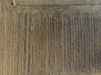 Drone view of plowed field covered in tire tracks - LOMF01330