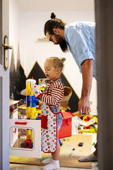 Father and son playing with toy kitchen at home - ASGF02139