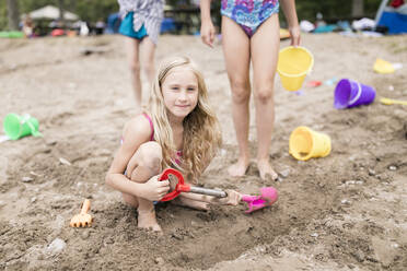 Mädchen mit Strandspielzeug spielen im Sand am Strand - ANF00103