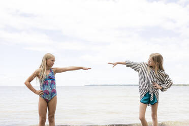 Freunde mit Hand auf der Hüfte am Strand stehend - ANF00104