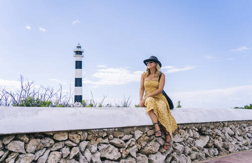 Glückliche Frau vor dem Leuchtturm von Artrutx im Sommer auf Menorca, Spanien - DGOF02278