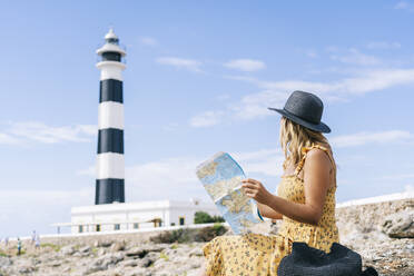 Tourist mit Landkarte am Leuchtturm von Artrutx auf Menorca, Spanien - DGOF02281