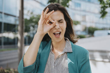 Happy businesswoman in smart casuals making ok gesture sign with hand - MFF08565