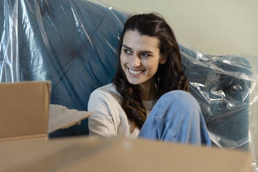 Contemplative woman by boxes at new home - EIF03404