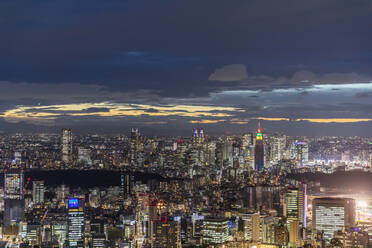 Japan, Kanto Region, Tokio, Bewölkter Himmel über beleuchteter Innenstadt bei Nacht - FOF12885