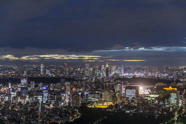 Japan, Kanto Region, Tokio, Bewölkter Himmel über beleuchteter Innenstadt bei Nacht - FOF12887