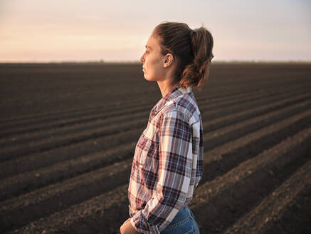 Nachdenklicher Bauer in einem landwirtschaftlichen Feld bei Sonnenuntergang - NOF00444