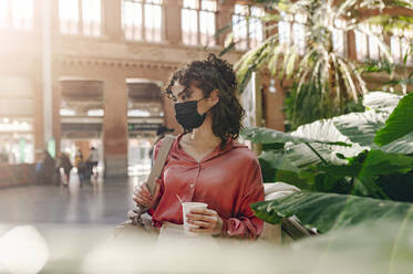 Young woman with protective face mask at train station - JCCMF05362
