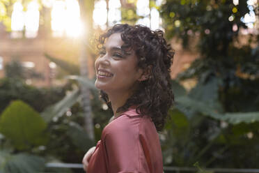 Happy young woman in garden - JCCMF05365