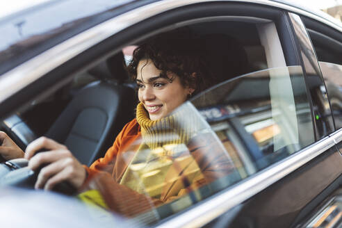 Young woman driving car on road trip - JCCMF05396