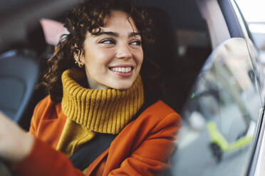 Lächelnde Frau blickt durch das Fenster eines Autos auf einer Autoreise - JCCMF05398