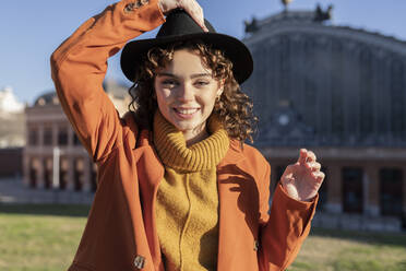 Smiling woman wearing hat on sunny day - JCCMF05402