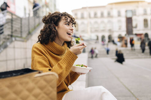 Happy woman having salad in city - JCCMF05444