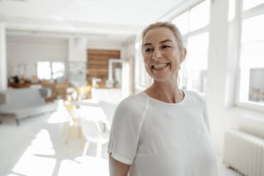 Cheerful businesswoman standing in office - KNSF09256