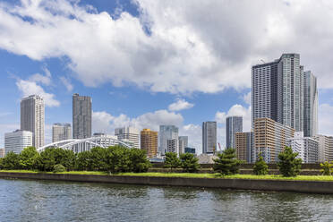 Japan, Kanto Region, Tokyo, Riverside promenade with downtown skyscrapers in background - FOF12896