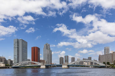 Japan, Region Kanto, Tokio, Wolken über Wolkenkratzern am Wasser mit der Kachidoki-Brücke im Vordergrund - FOF12898