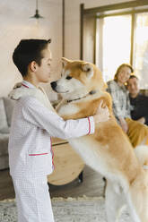 Boy playing with pet dog at home - SEAF00588