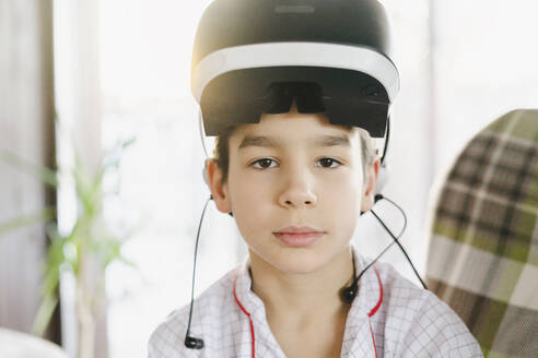 Junge trägt zu Hause einen Virtual-Reality-Simulator auf der Stirn - SEAF00590