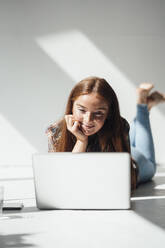 Smiling woman using laptop at home - JOSEF07204