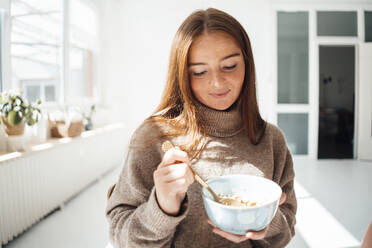 Young woman having breakfast at home - JOSEF07217