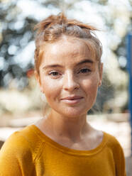 Smiling young woman in park - JOSEF07254