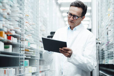 Pharmacist with tablet PC taking inventory in storage room - JOSEF07261