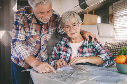 Ein älterer Mann und eine ältere Frau prüfen eine Straßenkarte zu Hause - SIPF02768