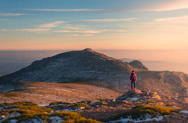 Back view of distant anonymous hiker standing on Sierra de Guadarrama mountain range during trekking in Spain on winter day - ADSF33650