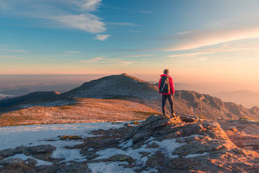 Back view of distant anonymous hiker standing on Sierra de Guadarrama mountain range during trekking in Spain on winter day - ADSF33651