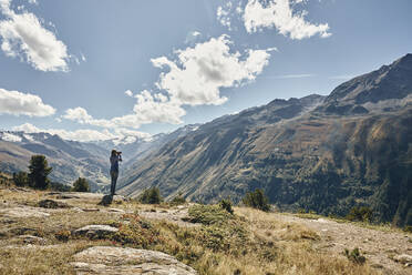 Tourist looking at Timmelsjoch mountain pass on vacation, Otztal Alps, Austria - SSCF00830