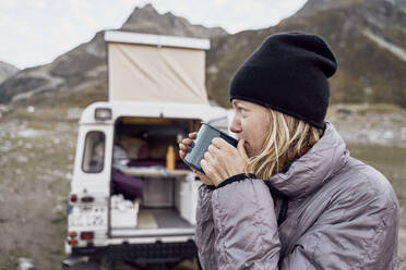 Thoughtful tourist having tea by motor home, Splugen Pass, Sondrio, Italy - SSCF00858