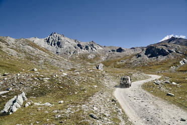 Off-road vehicle on gravel road at sunny day, Colle Sommeiller, Turin, Italy - SSCF00879