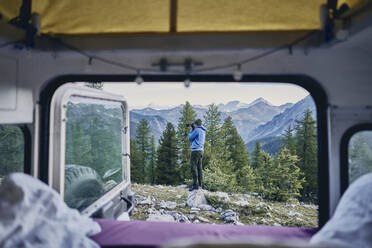 Man photographing seen through motor home on vacation - SSCF00887